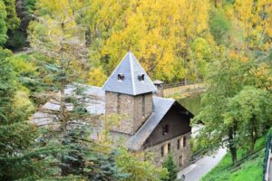 Charming stone house amidst lush green trees seen from above in Andorra la Vella.