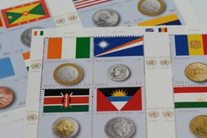 Image of diverse international coins and stamps featuring various countries' flags.