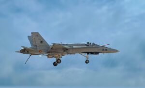 F/A-18 Hornet jet flying against clear blue sky, showcasing military aviation power.