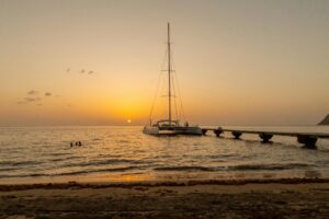 Magical sunset scene with a yacht near the pier on a serene evening in Dominica.