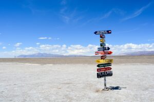 A bright signpost stands in a vast arid landscape with clear blue skies in Argentina.