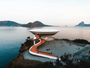 A breathtaking aerial view of the Niterói Contemporary Art Museum in Brazil, surrounded by sea and mountains.